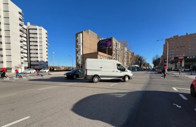 Coches y peatones cruzando en el cruce de Antonio López con Camino de Perales